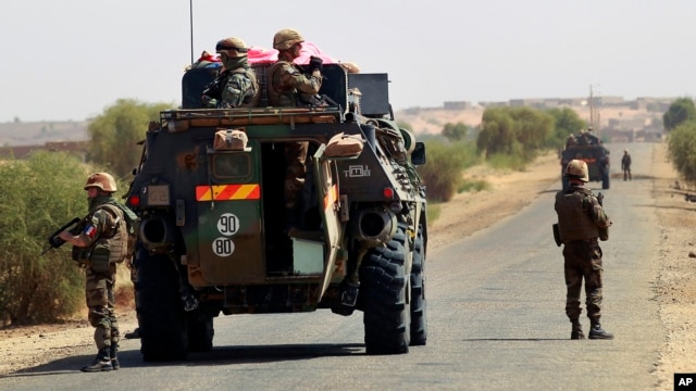 French Troops dismount to secure a demining team clearing the road near Hambori, northern Mali, on the road to Gao, February 4, 2013. 