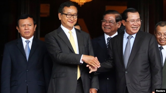Cambodia's Prime Minister Hun Sen (2nd R) shakes hands with Sam Rainsy (2nd L), president of the Cambodia National Rescue Party (CNRP), after a meeting at the Senate in central Phnom Penh July 22, 2014.