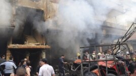 In this photo released by the Syrian official news agency SANA, Syrian citizens gather in front of a damaged building that was destroyed by a car bomb, at Jaramana neighborhood, in Damascus, Syria, Monday Oct. 29, 2012.