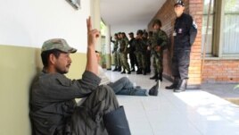 Un rebelde de las FARC capturado por la policía hace la señal de la victoria. Seis policías fueron asesinados por guerrilleros en el sureste de Colombia.