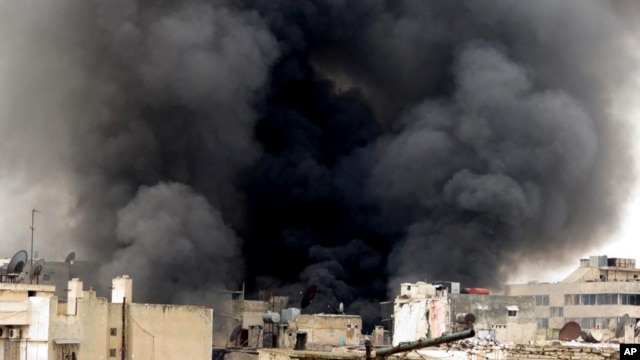 A citizen journalism image provided by Aleppo Media Center, which has been authenticated based on its contents and other AP reporting, shows black smoke rising from buildings due to government forces shelling, in Aleppo, Syria, March 19, 2013.