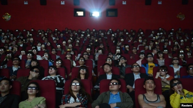 Espectadores ven un filme con espejuelos tridimensionales en una sala de cine en China.