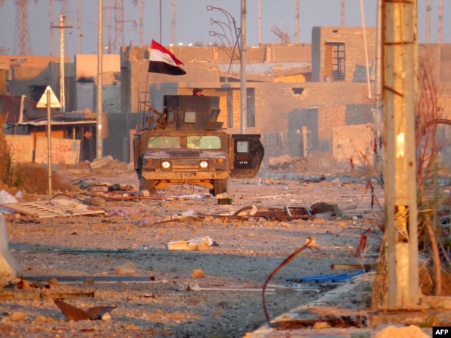 A member of Iraq's counter-terrorism forces monitors his surrounding in a street in Ramadi's Dhubbat neighberhood, adjacent to Hoz neighbourhood, Dec. 25, 2015.