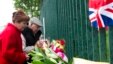 Pasangan Inggris berdoa di luar barak Woolwich, London (24/5), untuk tentara Inggris yang dibunuh sehari sebelumnya di jalan dekat barak. (AP/Bogdan Maran)