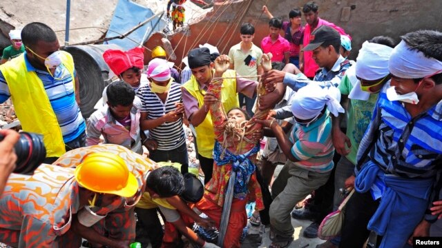 Nhân viên cứu hộ kéo một công nhân sống sót ra khỏi đống gạch đá của khu nhà bị sập