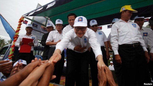 Cambodian opposition leader Sam Rainsy (C) greets his supporters in Kampong Speu province July 20, 2013.