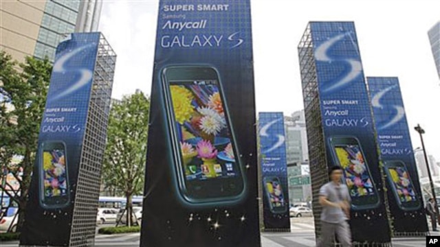 A man runs past Samsung Electronics Co.'s mobile phone Galaxy S advertisement outside its head office in Seoul, South Korea (FILE).