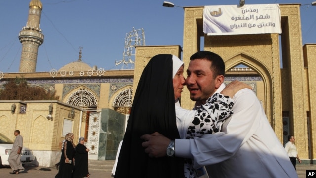 Iraqi Sunni Muslims exchange greetings after Eid prayers outside Abu Hanifa mosque at the first day of Eid al-Fitr prayers in Baghdad, Iraq, August 19, 2012. 