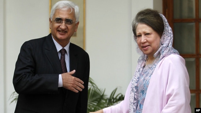 Indian Foreign Minister Salman Khurshid, left, prepares to shake hands with Bangladesh's opposition leader Khaleda Zia as they pose for the media before a meeting in New Delhi, India, October 30, 2012.
