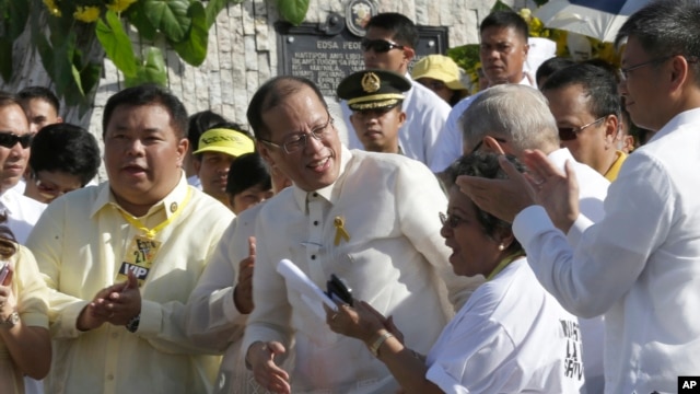 Philippine President Benigno Aquino III, center, is applauded by lawmakers after signing into law the Human Rights Victims Reparation and Recognition Act of 2013, Feb. 25, 2013.