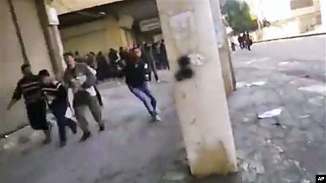This image from amateur video purports to shows Syrian protesters running from gunfire in Hama, Syria, December 28, 2011.