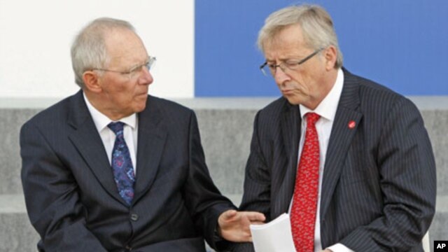Germany Finance Minister Wolfgang Schauble (L) talks to Eurogroup President Jean-Claude Juncker after posing with other European Union finance ministers for a photo during a meeting of the Economic and Financial Affairs Council in Wroclaw, Poland, Septemb