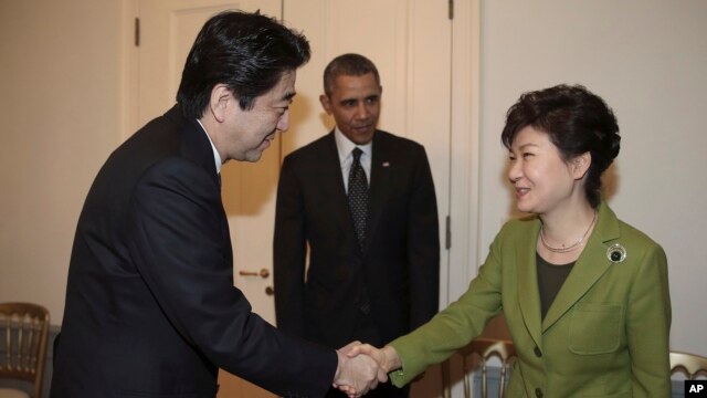 Tổng thống Nam Triều Tiên Park Geun-hye bắt tay Thủ tướng Nhật Bản Shinzo Abe. Tổng thống Obama đã đưa hai nhà lãnh đạo Nhật Bản và Nam Triều Tiên ngồi lại với nhau tại cuộc họp ở La Haye, ngày 25/3/2014.