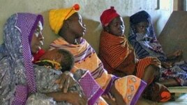 FILE - African women waiting for medical care.