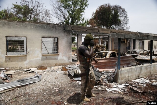 A soldier walks through the burnt building at the headquarters of Michika local government in Michika town, after the Nigerian military recaptured it from Boko Haram, in Adamawa state, May 10, 2015.