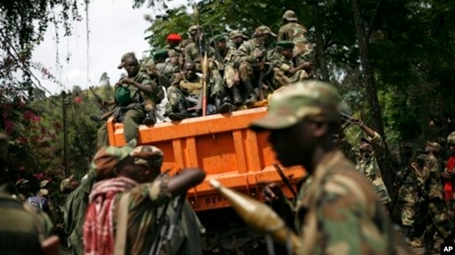 FILE - M23 rebels sit in a vehicle as they withdraw from the eastern Congo town of Goma, Dec. 2012.