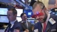 A trader wears glasses in the shape of 2015 while working on the floor at the New York Stock Exchange in New York, Dec. 31, 2014.