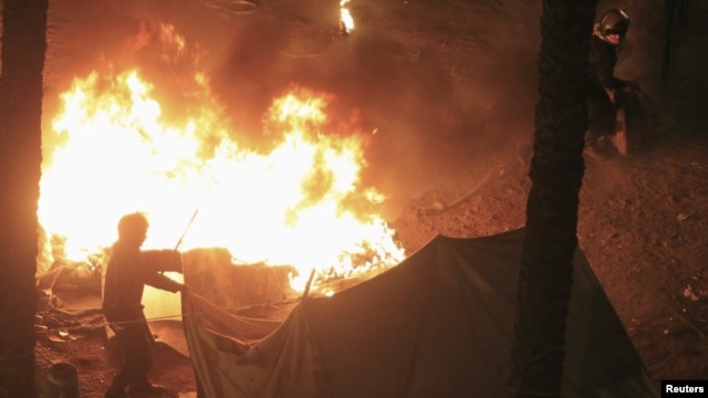 Riot police set fire to tents pitched by anti-Mursi demonstrators at Tahrir Square in Cairo January 25, 2013. 