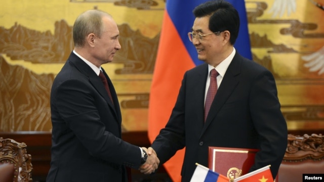 China's President Hu Jintao and Russian President Vladimir Putin shake hands in Beijing, June 5, 2012.