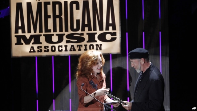Bonnie Raitt, left, presents the Lifetime Achievement Songwriting Award to Richard Thompson at the 11th annual Americana Honors & Awards, Sept. 12, 2012, in Nashville. (Photo by Wade Payne/Invision)