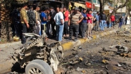 Residents are seen inspecting the site of a car bomb attack in the Karrada district in Baghdad February 17, 2013.