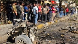 Residents are seen inspecting the site of a car bomb attack in the Karrada district in Baghdad February 17, 2013.