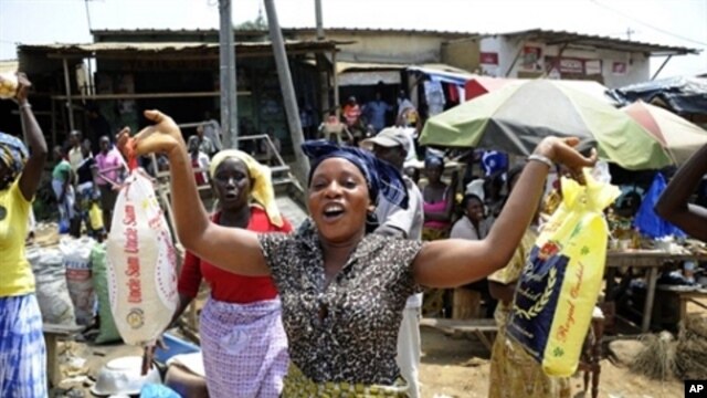 A woman holds bags of rice at a market in Abidjan on April 14, 2011