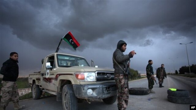 Libyan security forces stand guard at a checkpoint on the highway leading to downtown Benghazi, Libya, Feb. 15, 2013. Libyans are preparing to mark the second anniversary of the uprising that ousted Moammar Gadhafi.