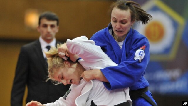 Kayla Harrison of US, in white, fights with Vera Moskalyuk of Russia during the women's under 78 kg category final match at the World Cup Judo tournament in Budapest, Hungary, February 12, 2012.