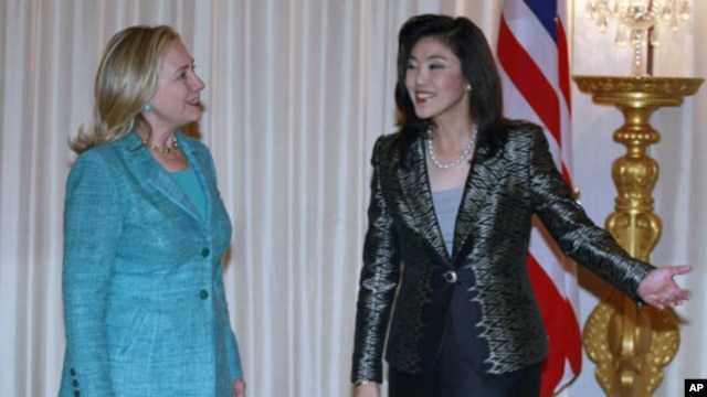 Thailand's Prime Minister Yingluck Shinawatra shows U.S. Secretary of State Hillary Clinton (L) the way during their meeting at the Government House in Bangkok November 16, 2011.