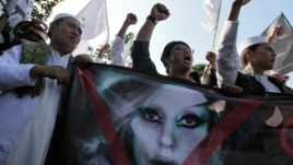 Muslim men shout slogans during a rally against US pop singer Lady Gaga's concert that is scheduled to be held on June 3, outside the US Embassy in Jakarta, Indonesia, May 25, 2012. 