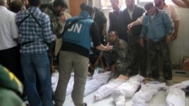 Handout photo released by Syrian opposition's Shaam News Network shows UN observers at hospital morgue before their burial in central Syrian town of Houla on May 26, 2012.
