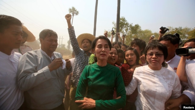 Burma pro-democracy Leader Aung San Suu Kyi poses for a photo as villagers protest against an investigation commission's report on a copper mine project in Sarlingyi township, March 14, 2013. 