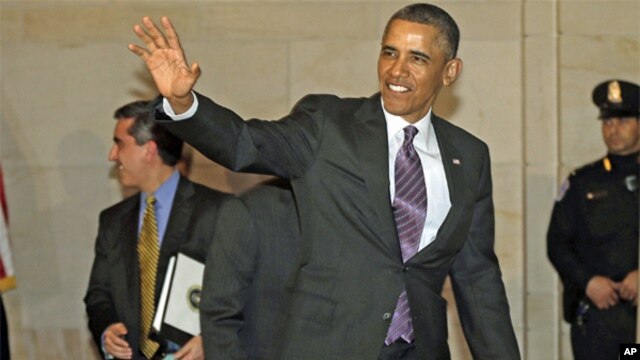 President Barack Obama waves to members of the media as he heads to a meeting with House Democratic Caucus on Capitol Hill in Washington,  March 14, 2013.