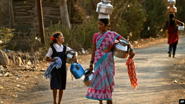 In this Wednesday, March 13, 2013 photo, Indian villagers walk to fetch drinking water at Kasu village, in the western Indian state of Maharashtra.