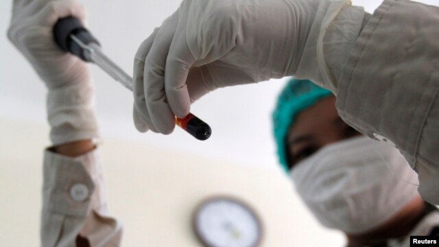 Một nhân viên y tế bệnh viện số 9 tại Hà Nội đang xem mẫu máu của một bệnh nhân HIV. Đây là bệnh viện đầu tiên và duy nhất tính tới thời điểm hiện tại ở miền Bắc cung cấp việc điều trị cho các bệnh nhân HIV/AIDS giai đoạn cuối. REUTERS/Kham  