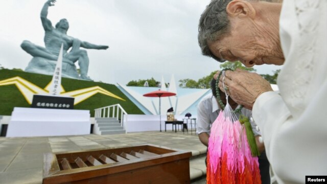 Shigeko Iwamoto, who survived the 1945 atomic bombing of Nagasaki, offers prayers for the victims in front of the Peace Statue in Nagasaki's Peace Park, August 9, 2012. 
