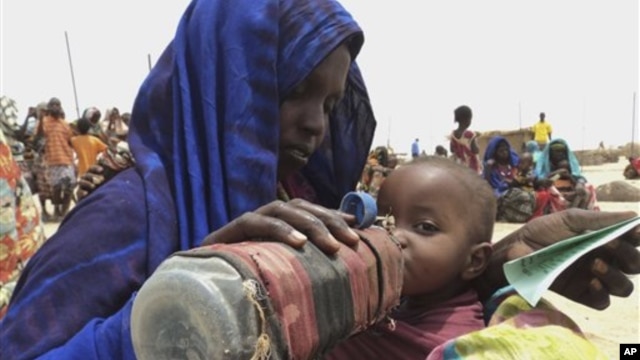 A mother quenches her malnourished child's thirst while waiting for food handouts at a health center in drought-stricken remote Somali region of Ethiopia, July 9, 2011.