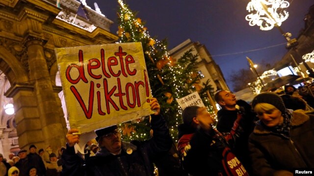 A man holds a placard during an anti-government protest called by civil groups in Budapest, Hungary, Jan. 2, 2015.
