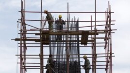 Workers stand on scaffolding at a road construction site in Beijing (File).