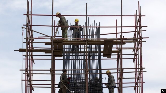 Workers stand on scaffolding at a road construction site in Beijing (File).