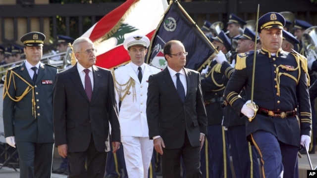Lebanese President Michel Suleiman, second left, and French President Francois Hollande, second right, review honor guards, at the Presidential Palace in Baabda, east of Beirut, Lebanon, November 4, 2012.