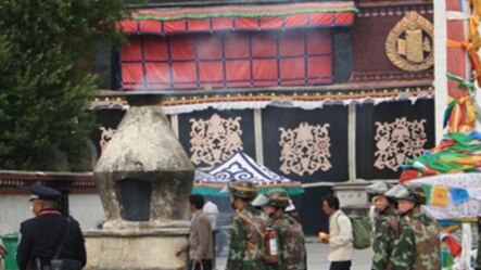 Chinese military personnel carrying fire extinguisher walks in front of Jokhang temple at Barkor Square in Lhasa, Tibet