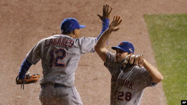 Juan Lagares (12) de los NY Mets celebra con Daniel Murphy (28) luego del tercer juego de la Serie de Campeonato de la Liga Nacional contra los Cachorros de Chicago, el martes 20 de octubre, de 2015.