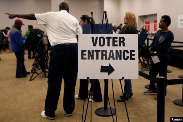 FILE - Voters wait in line to cast their ballots during early voting at the Franklin County Board of Elections in Columbus, in Columbus, Ohio.