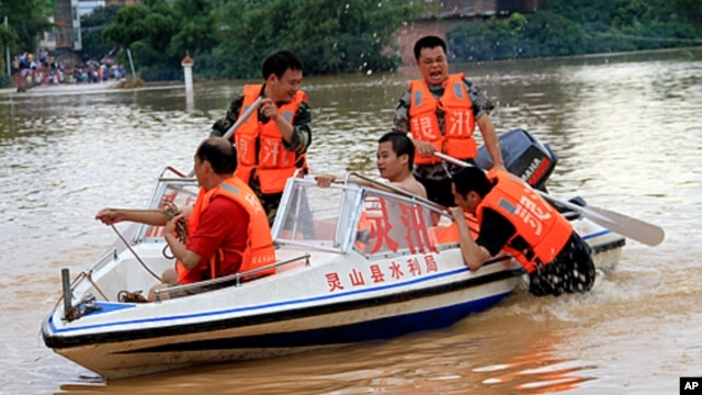 Chinese rescuers try to help residents cross a flooded street in Qinzhou, southwest China's Guangxi province on October 3, 2011.