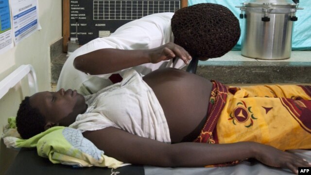 An employee at the Health Care center IV of Busiu in Mbale district, eastern Uganda attends to Mary Watera, who is pregnant with her first baby,  September 27, 2011.
