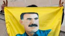 FILE - A Kurdish demonstrator holds a flag with a portrait of jailed Kurdistan Workers Party (PKK) leader Abdullah Ocalan in Strasbourg, France, Feb.14, 2009.