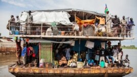 Southern Sudanese people arrive in a barge at the port in Juba, August 31, 2012. 