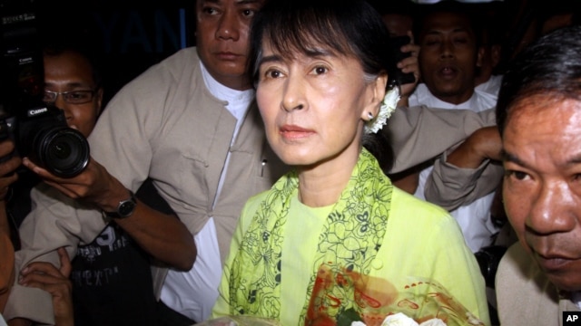 Burmese opposition leader Aung San Suu Kyi, center, arrives at Rangoon International airport to leave for United State Sunday, Sept . 16 2012, in Yangon.